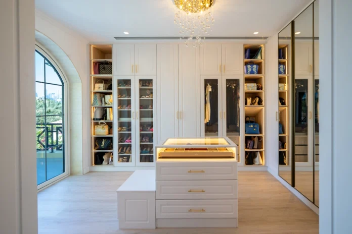 Luxury home renovation in Dubai featuring an elegant walk-in closet with custom cabinetry and a chandelier.